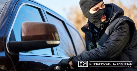 masked man breaking into a car
